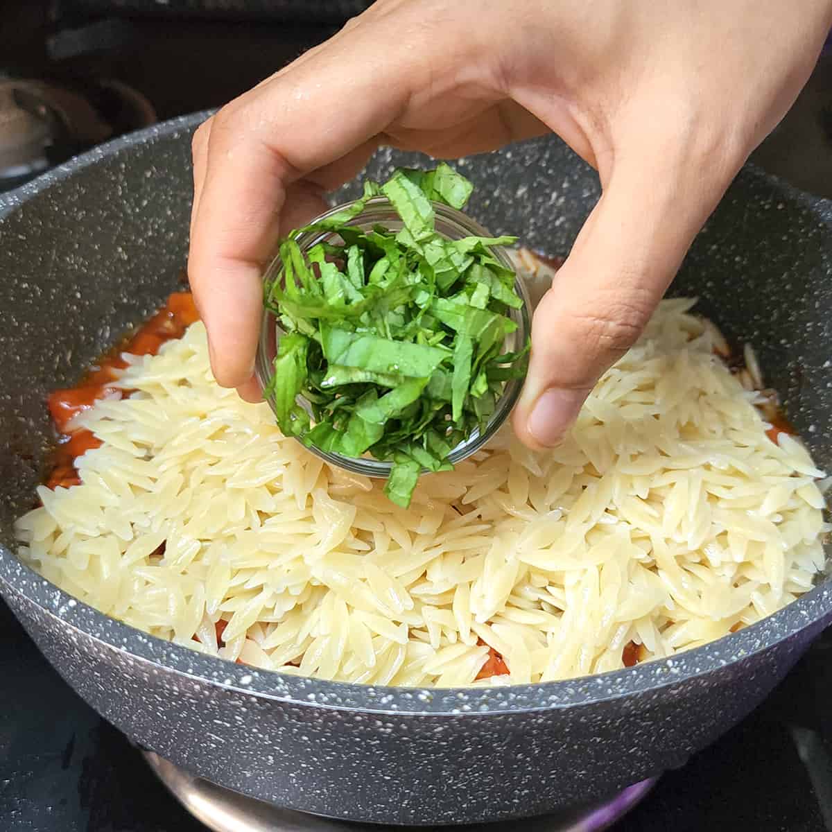 Add fresh basil leaves to the pan in which pasta is being cooked.