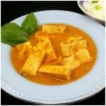 Easy homemade Pad Ped Tofu in a white bowl garnished with Basil leaves.