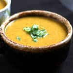 Best and easy lentil soup on serving bowl garnished with cilantro.