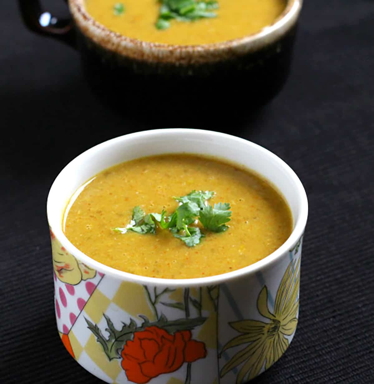 healthy and easy lentil soup on 2 serving bowls garnished with cilantro. 