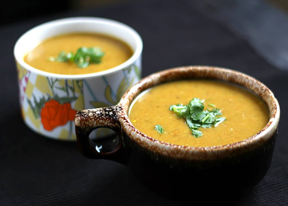 Best lentil soup on serving bowl garnished with cilantro.