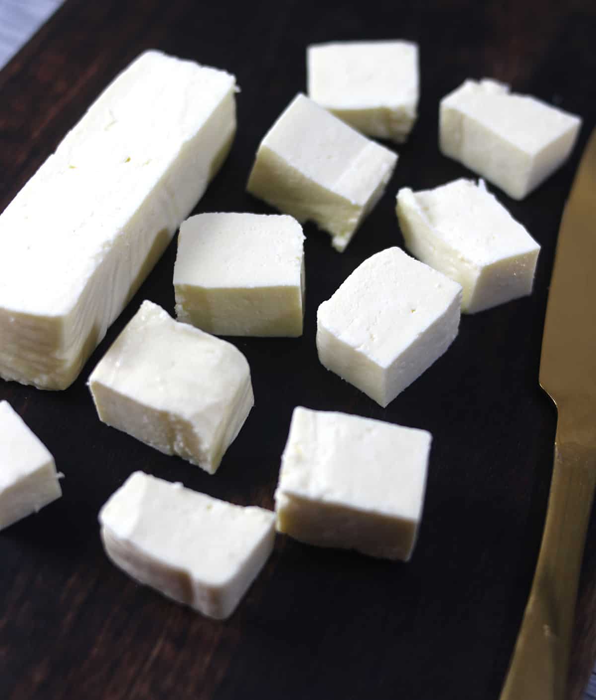 Best homemade paneer cheese cubes on a serving board (Indian cottage cheese). 