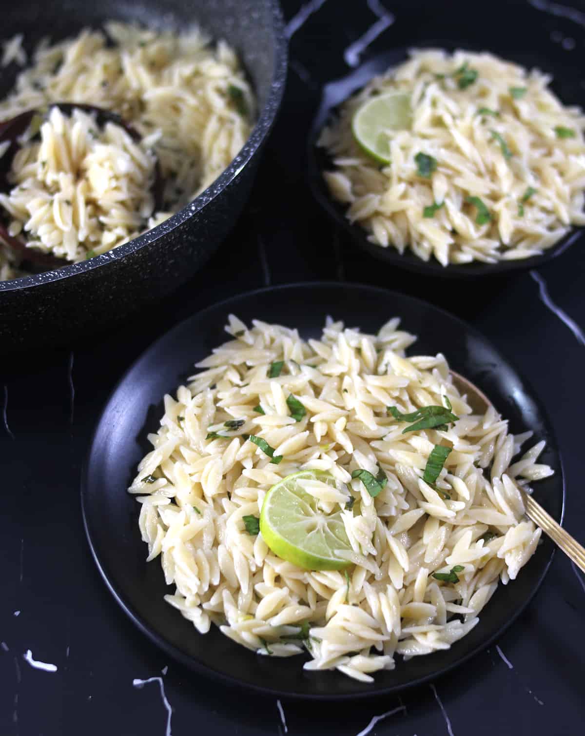 Best one pot lemon orzo pasta served on black plate with golden spoon. 