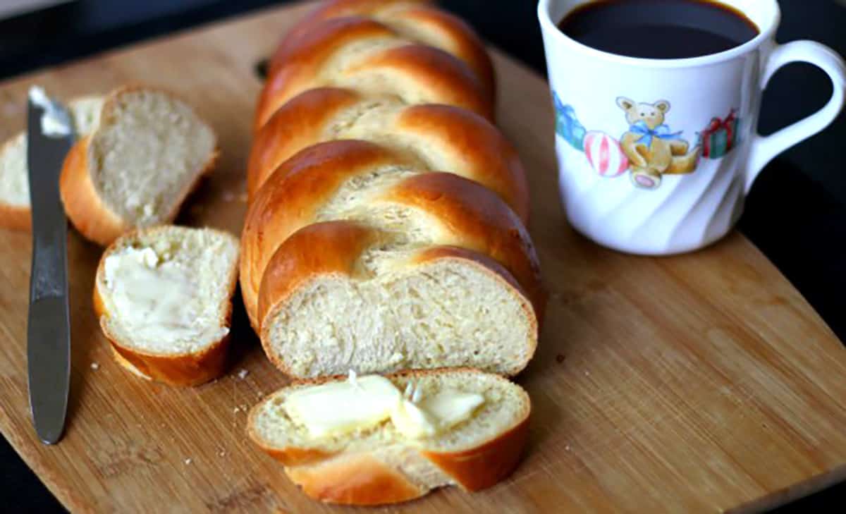 Swiss braided zopf or zupfe bread slice with butter and cup of coffee. 