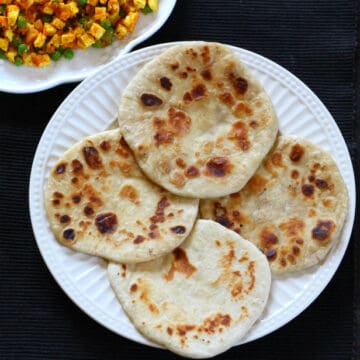 Four thai roti breads served in a white plate, along with tofu bhurji on another plate.