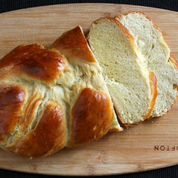 braided, best and easy Jewish challah bread loaf with slices on a serving board.