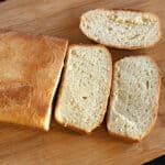 best homemade potato bread loaf with few slices on a serving board.
