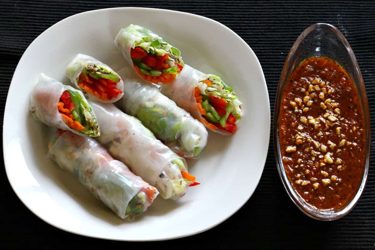 Summer rolls or rice roll wrappers in serving plate with peanut dipping sauce. 