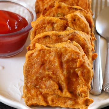 best bread pakora or bread bajji served on a white plate with tomato ketchup.