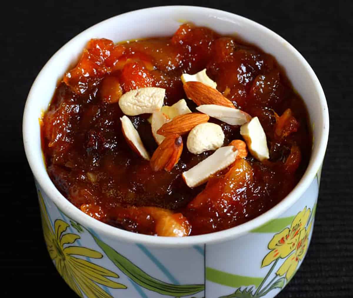 Easy peach mango halwa Indian dessert garnished with nuts in a serving bowl. 