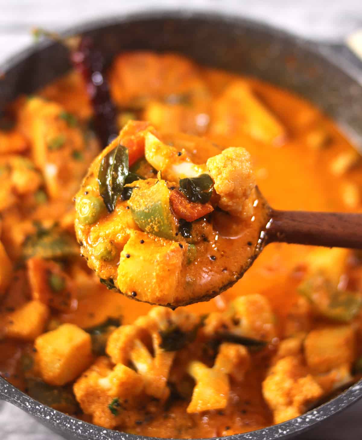 A laddle full of spicy cauliflower potato curry (vegan aloo gobi curry for any meal).