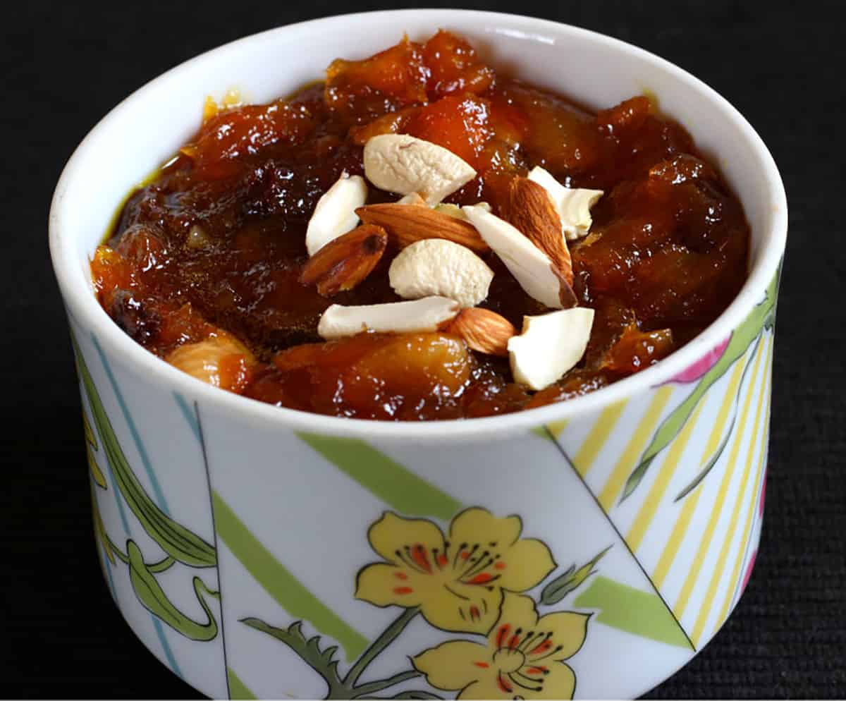 flourless fruit halwa dessert made with peaches and mangoes in a white serving bowl. 