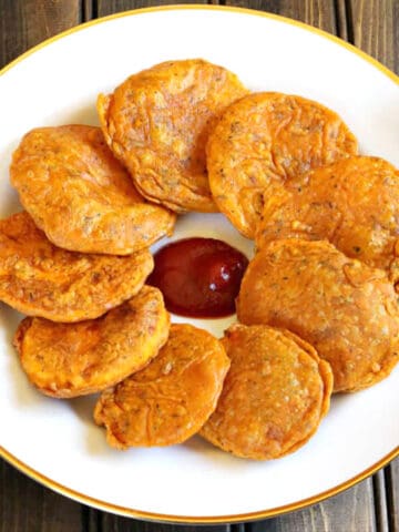 Crispy, easy-to-make sweet potato fritters (Best Indian pakoras, bajji, podi) on a serving plate.