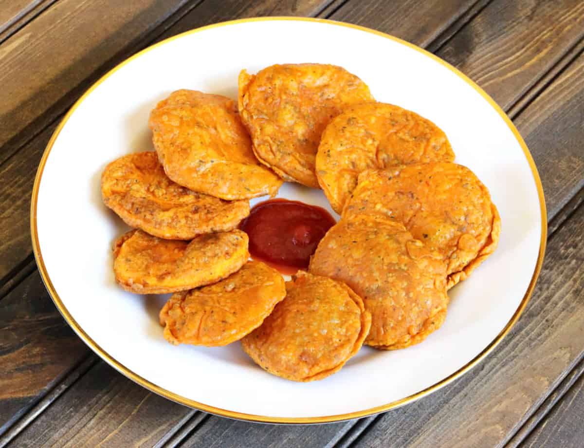 Best snacks or finger food with sweet potatoes (Sweet potato fritters or pakora on serving plate). 