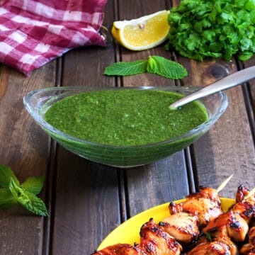 Indian green chutney or Coriander mint chutney in a bowl with spoon for sandwiches, chaats, snacks.