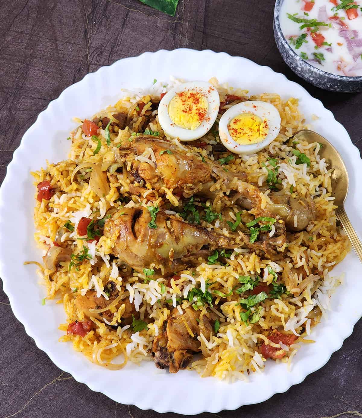 Easy Indian chicken biryani recipe. Best biryani with chicken served with boiled egg & raita salad.