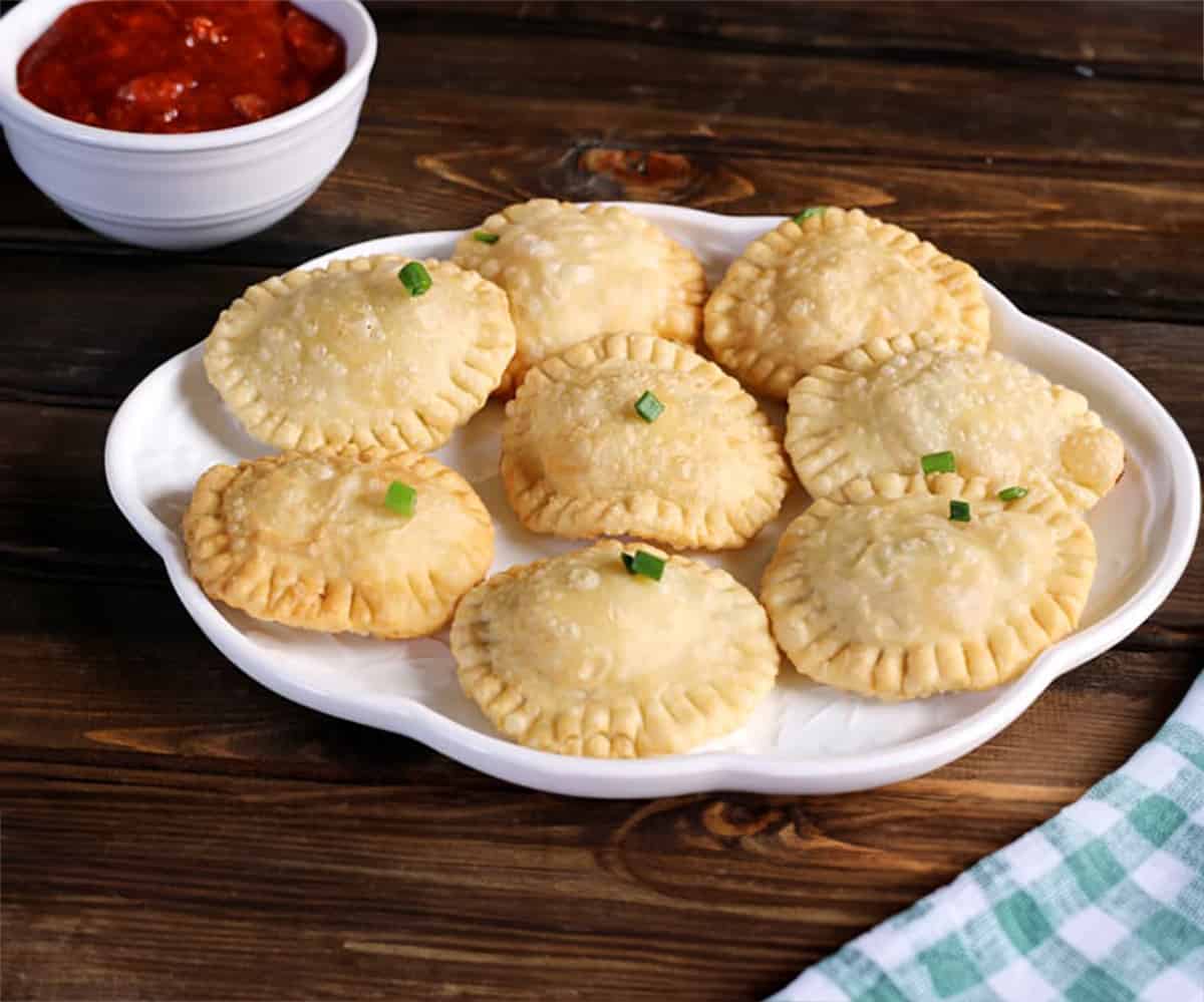 Must-try mushroom and cheese fried ravioli served in white ceramic plate.