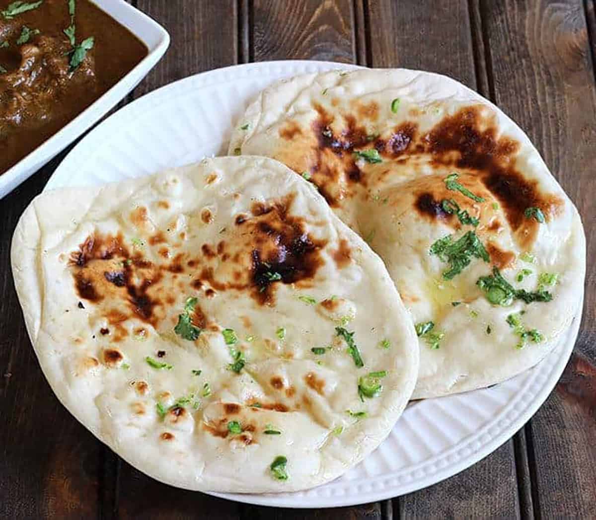 simple homemade naan bread brushed with butter and herbs, served with chicken curry.