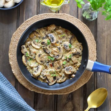 Creamy garlic mushrooms in a black pan. (mushroom in garlic cream sauce)