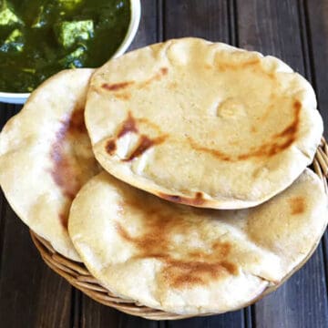 quick and best whole wheat naan bread (atta naan) in a basket served with palak paneer.