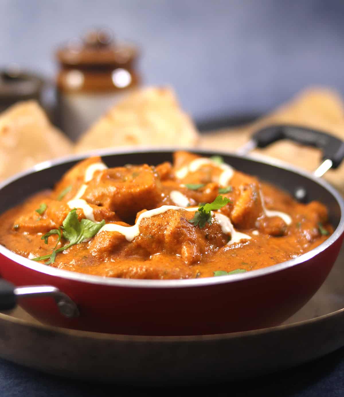 Classic and popular Indian butter chicken or murgh makhani curry served in kadai with chapati, roti.