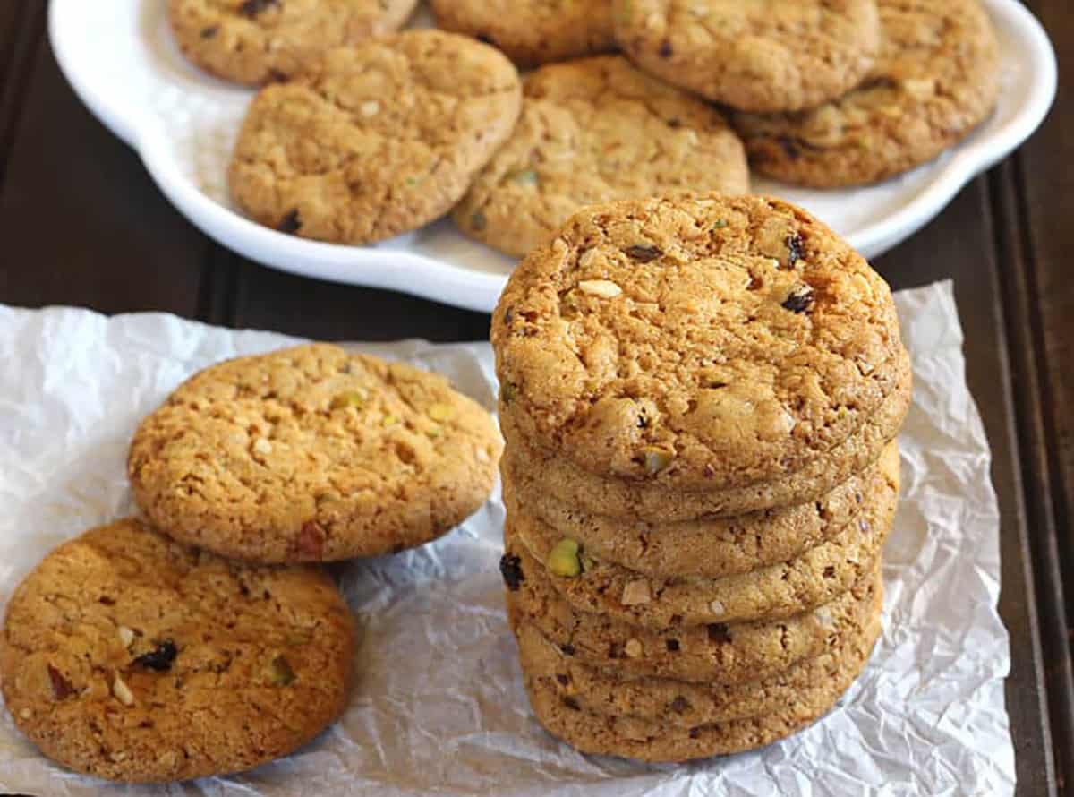 Stack of best dry fruit cookies or butter cookies on a white parchment paper. 