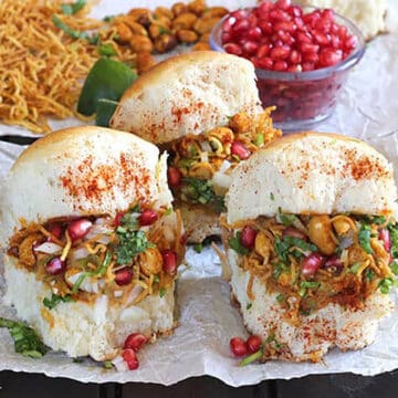 kacchi dabeli Indian snack stuffed with aloo (potato) masala, spicy peanuts, chutney, sev, onions.