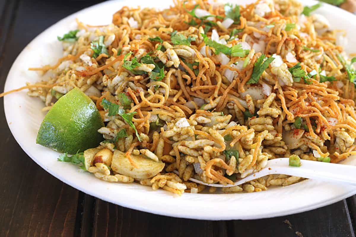 chatpati low calorie bhel chaat on a white plate with spoon. 
