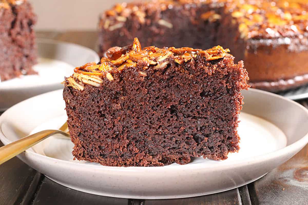 Slice of soft and moist, light and fluffy chocolate cake with caramel almond topping. 