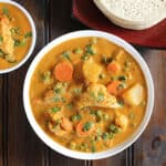 quick and easy vegetable korma (kurma) in a white bowl served with dosa.