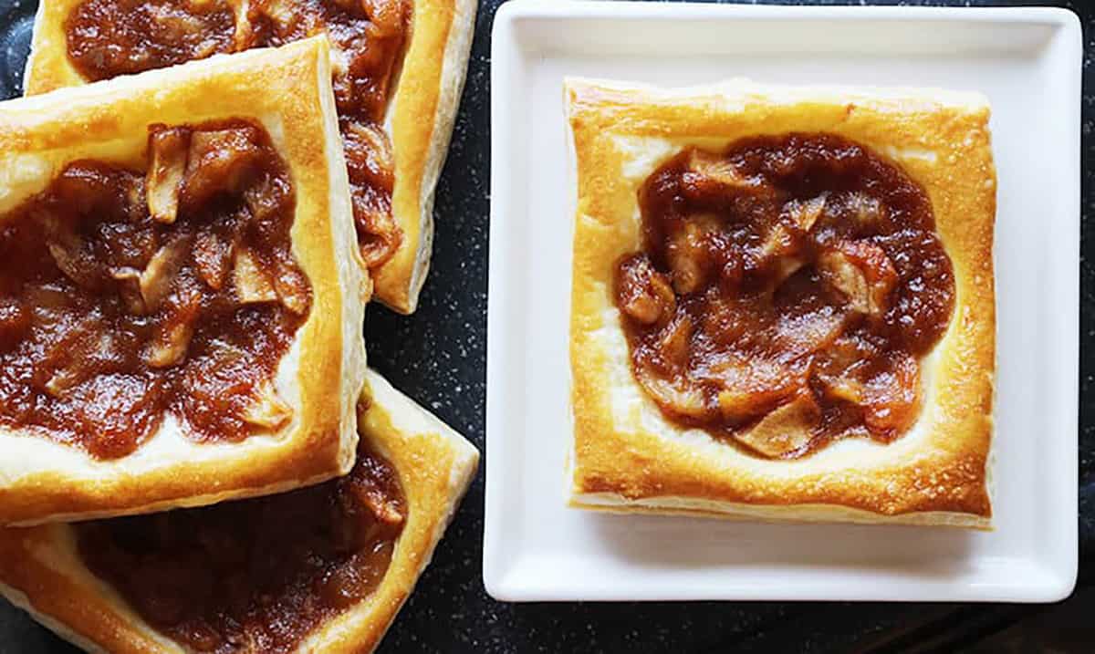 mini apple tarts with puff pastry on a serving plate. 