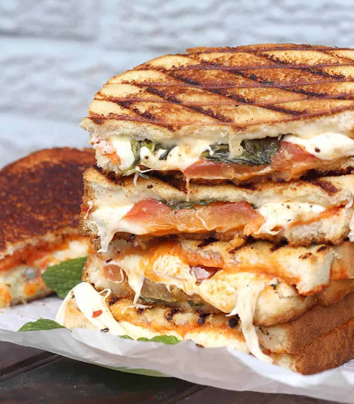 stack of grilled cheese sandwich with fresh mozzarella, basil, tomatoes and thick bread slices. 