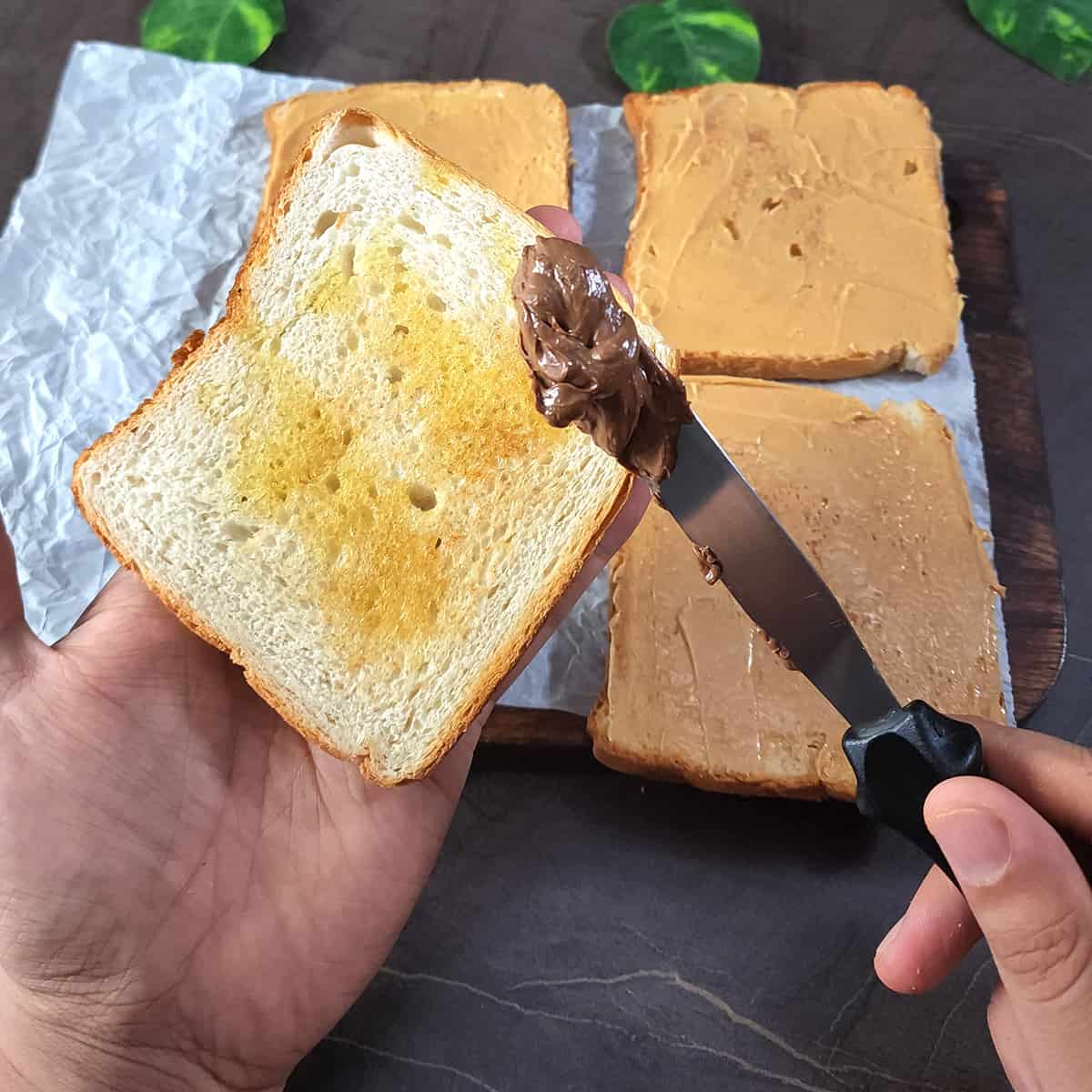 Spread nutella on top of toasted bread using a butter knife.