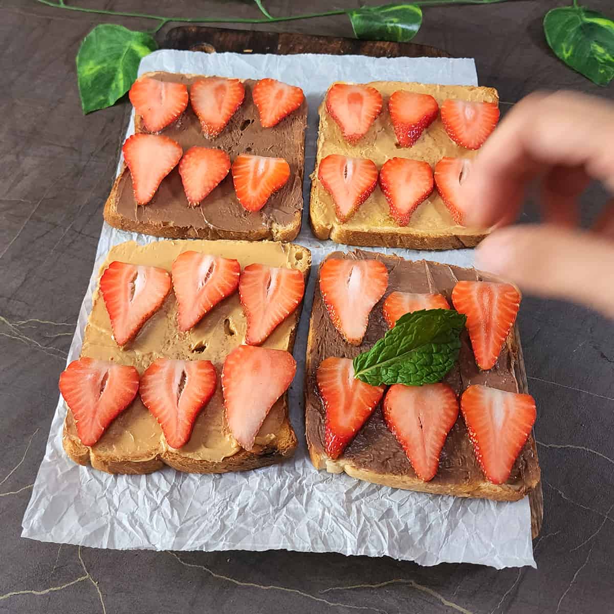 Garnish strawberry nutella bread toast with fresh mint leaves.