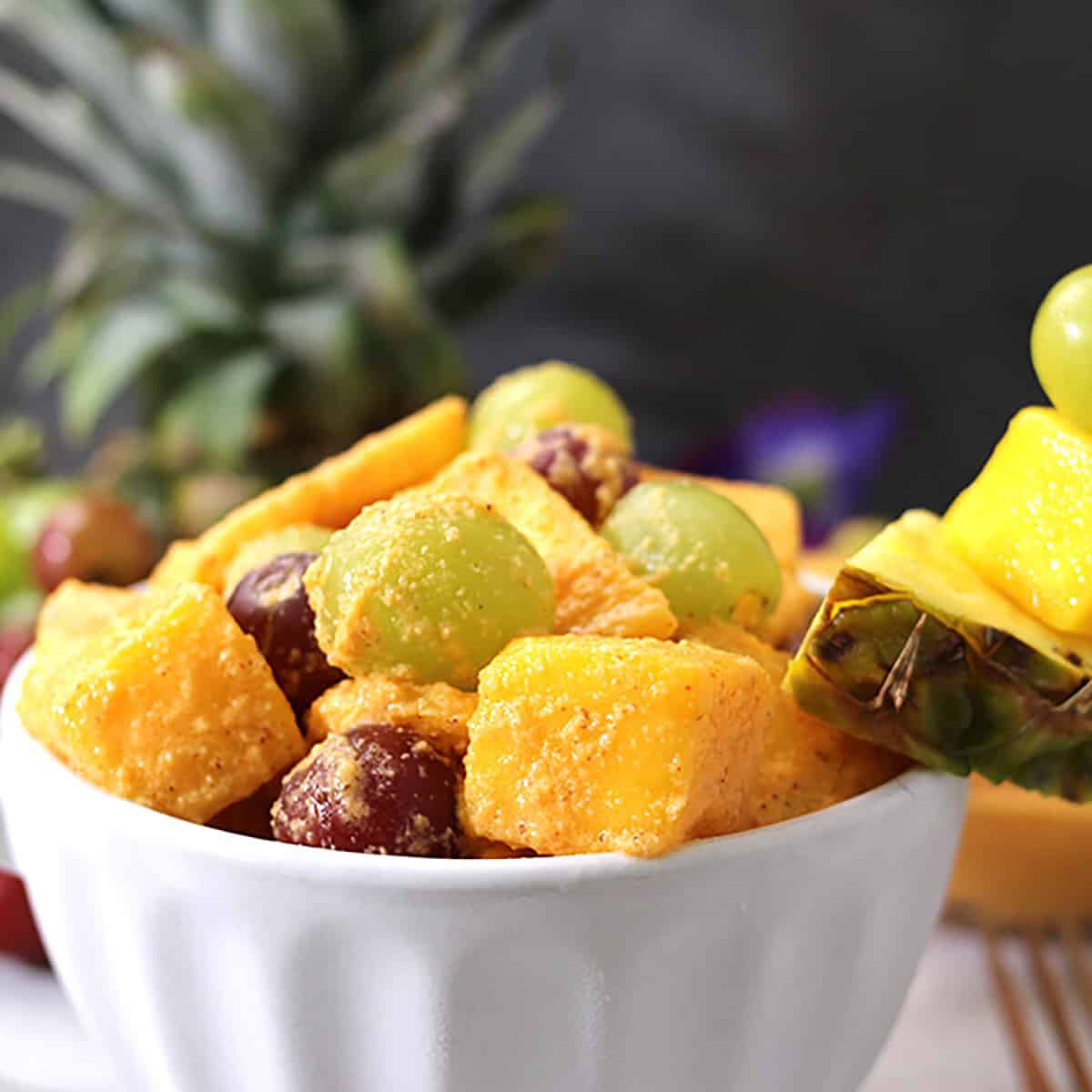 Close up picture of tropical fruit salad with pineapple, mangoes and coconut dressing. 