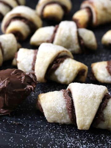 Best quick Nutella crescent rolls with tablespoon of Nutella chocolate hazelnut spread on a black plate.