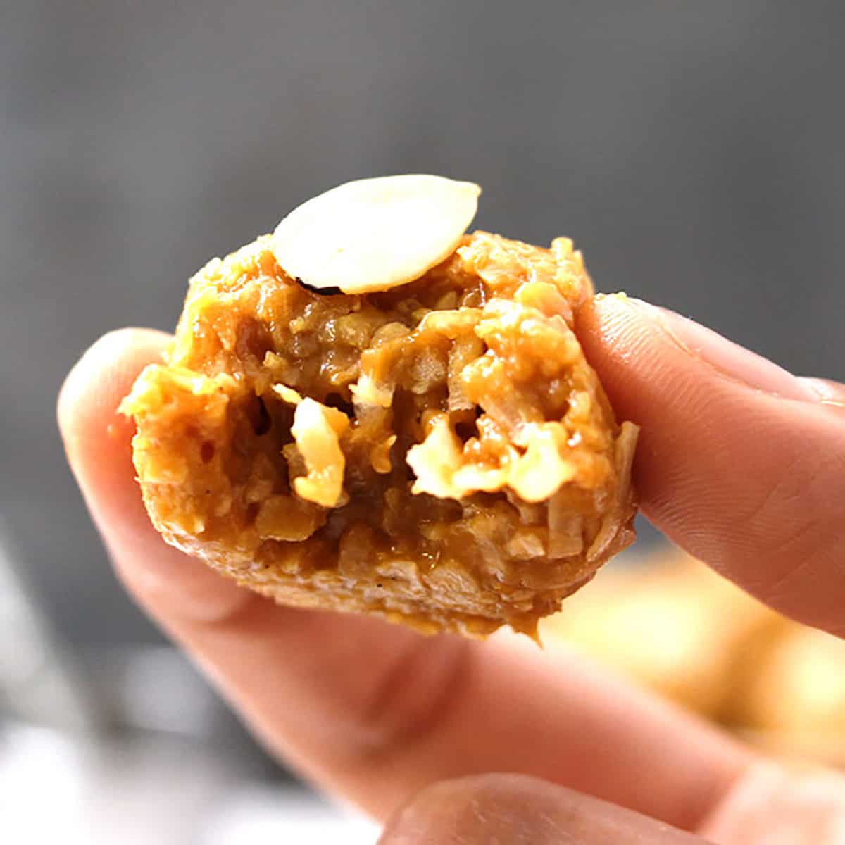 Holding best and moist no-bake coconut balls or coconut ladoo with dulce de leche. 