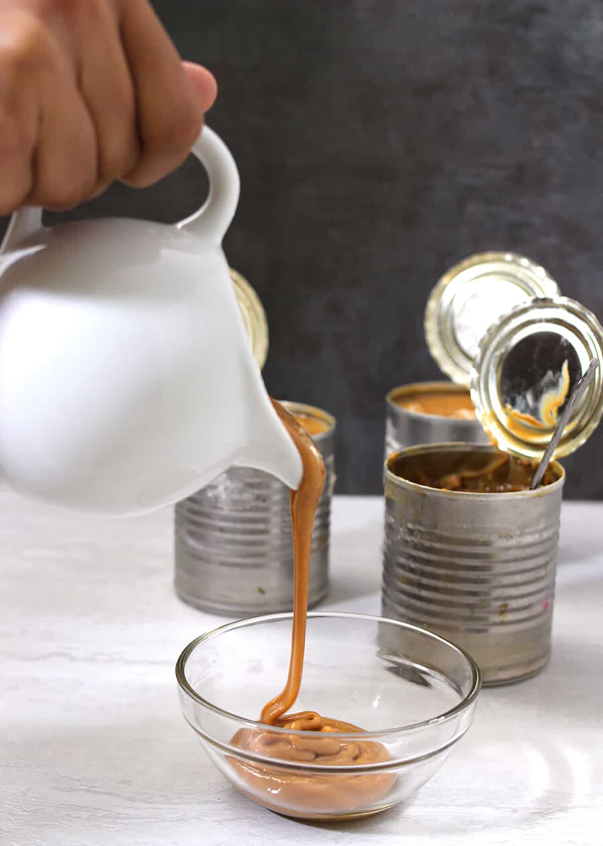 Pouring best and easy homemade dulce de leche to a bowl. 