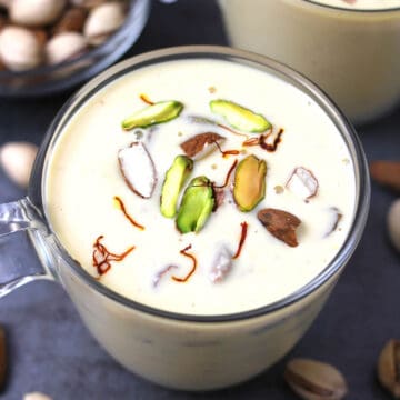 Basundi sweet - traditional best Indian milk dessert served in a serving glass garnished with nuts.