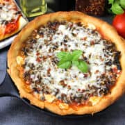 Thai-style deep dish pizza served in a cast iron pan.