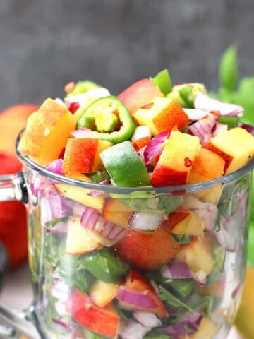 Spicy and easy fresh peach salsa in a serving glass bowl!