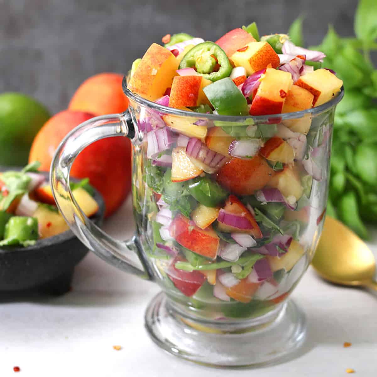 Fresh Peach Salsa filled in tall glassware, ready to serve. 