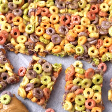 Fruit Loop Bars or No Bake Cereal Bars cut in pieces and served on parchment paper.