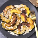 Easy roasted acorn squash slices for dinner served with garlic cream sauce.
