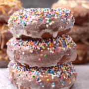 Three glazed doughnuts with sprinkles.