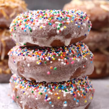 Three glazed doughnuts with sprinkles.