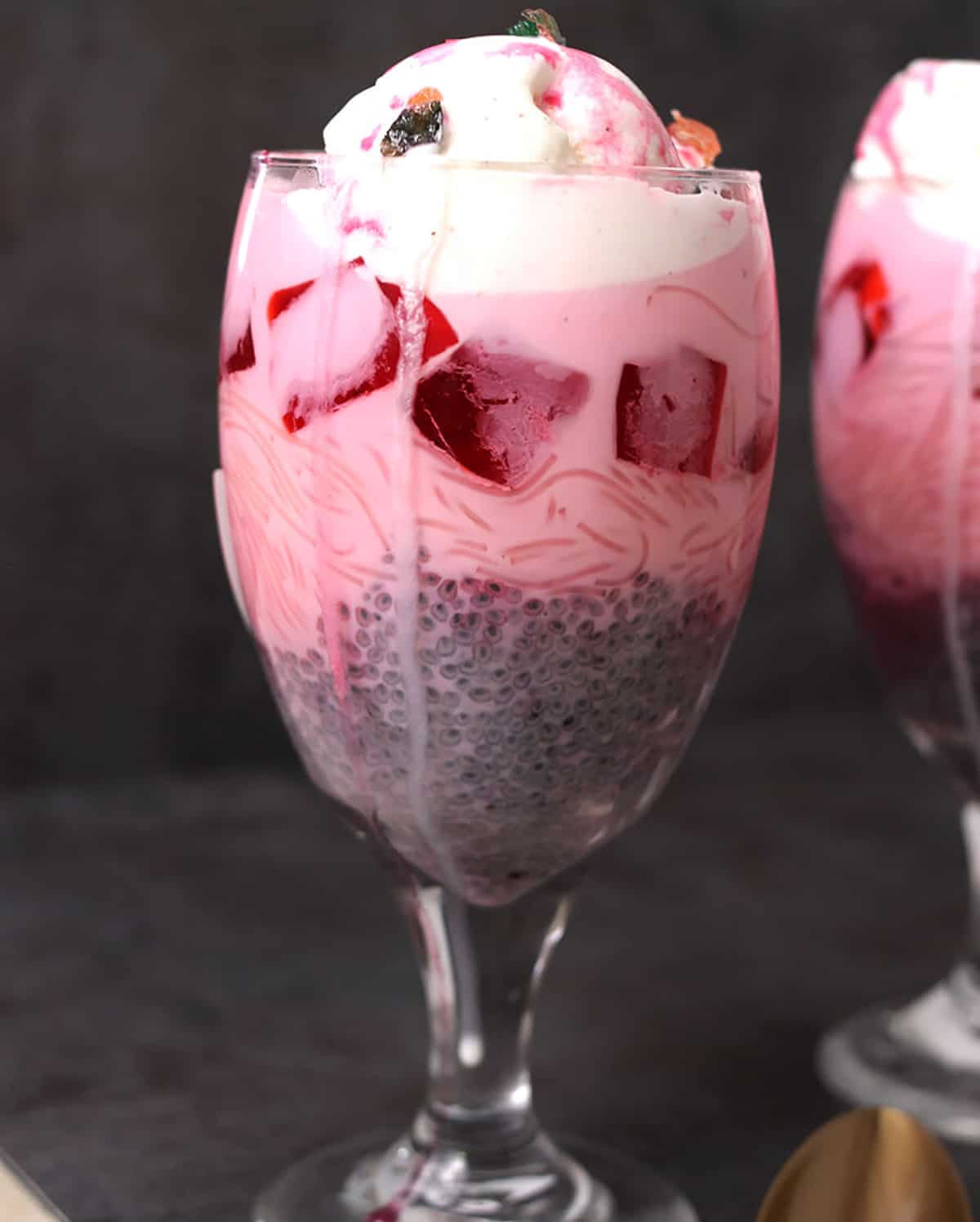 Falooda Indian layered dessert with sweet basil seeds, rose syrup, milk, jelly, ice cream, nuts. 