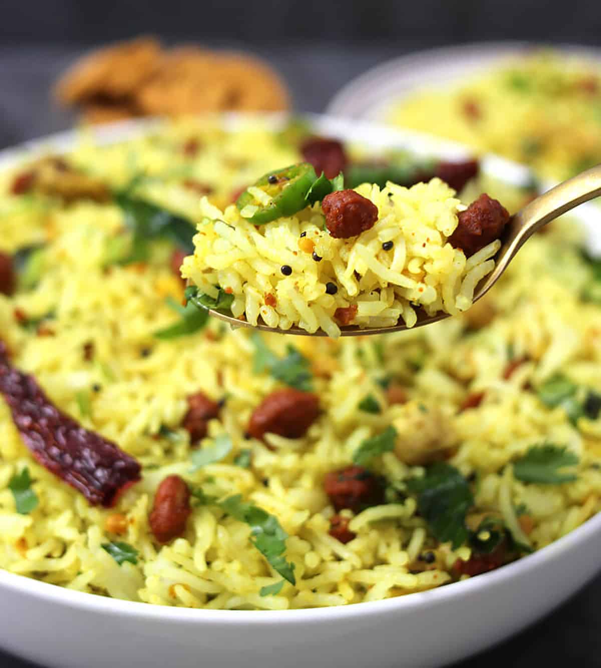 Holding lemon rice or chitrannam in spoon #lunchboxrecipes #noonionnogarlic