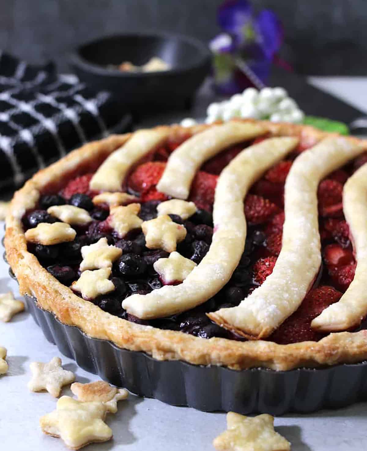 4th of july themed patriotic berry pie in pie pan. 