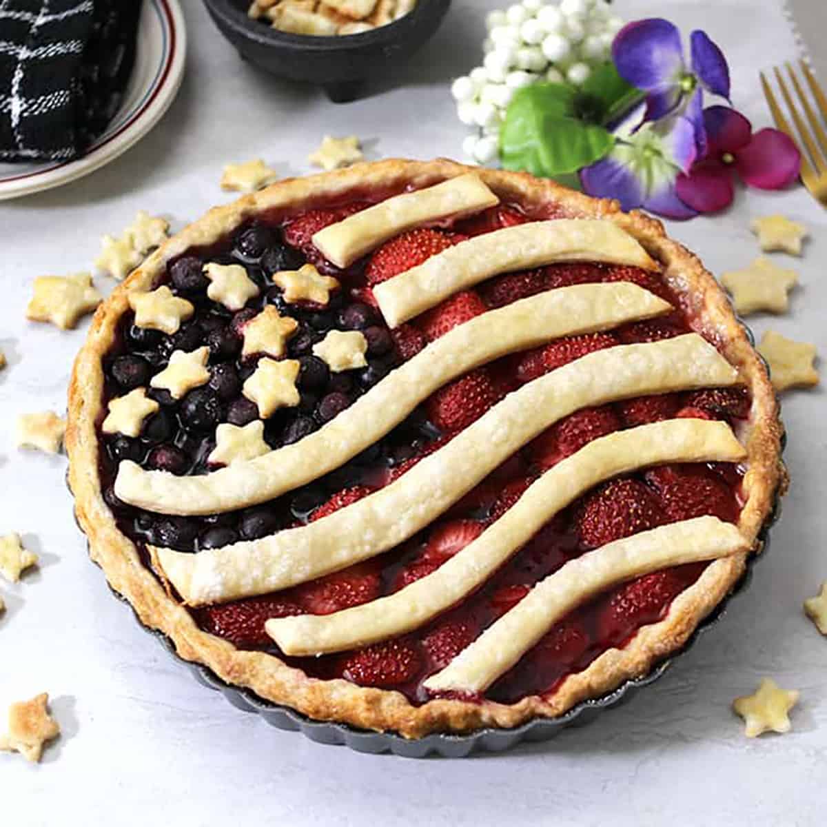 patriotic red white and blue pie dessert with strawberries and blueberries. 